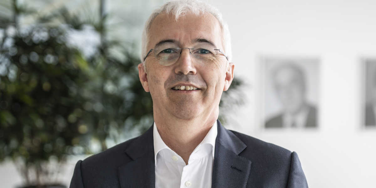 Mann im Büro, Pflanze im Hintergrund