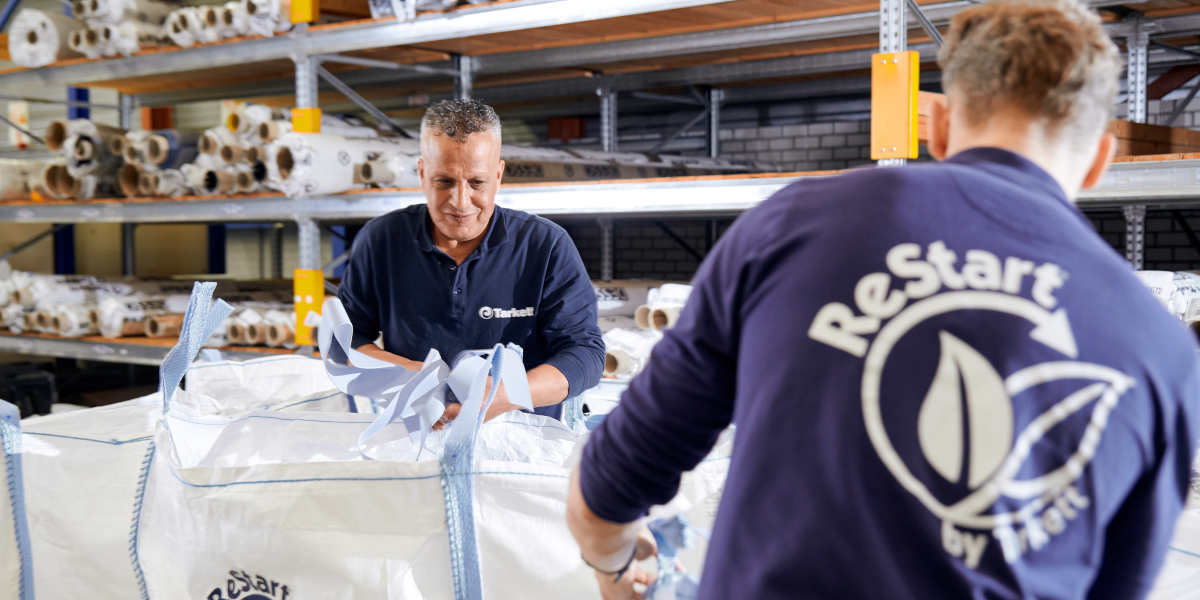 Tarkett Mitarbeiter im Recyclingzentrum im schwedischen Ronneby sichten die Verschnittreste und gebrauchten Bodenbeläge, die in Big Bags von „Tarkett ReStart“ Partnern wie z. B den IKEA-Einrichtungshäusern zurückgenommen werden.